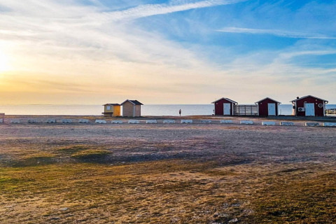 Sonnenuntergang am Strand von Löttorp, Schweden, mit kleinen Ferienhäusern und ruhigem Meer.