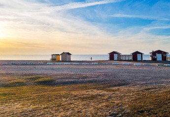 Sonnenuntergang am Strand von Löttorp, Schweden, mit kleinen Ferienhäusern und ruhigem Meer.