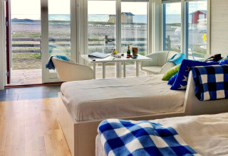 Intérieur du gîte 3 personnes à Löttorp, Suède, avec une décoration moderne et vue sur la mer.
