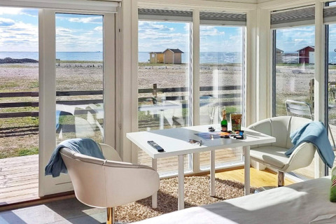 Licht vakantieverblijf in Löttorp, Zweden, met zeezicht door grote ramen en moderne inrichting.