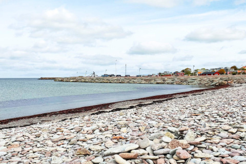 Rotsachtig strand en kalme kust bij een vakantiewoning in Löttorp, Zweden, met uitzicht op zee.