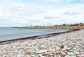 Rotsachtig strand en kalme kust bij een vakantiewoning in Löttorp, Zweden, met uitzicht op zee.
