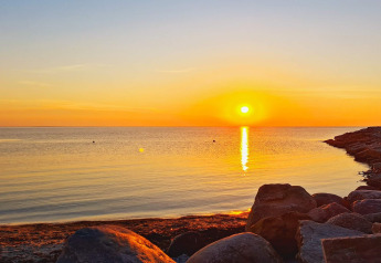 Atardecer sobre el mar tranquilo y rocas, visto desde la casa de vacaciones para 3 personas en Löttorp, Suecia.