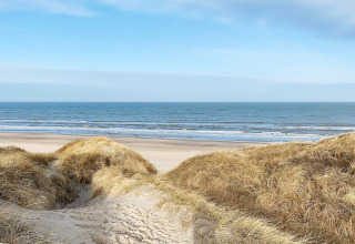 Uitzicht vanop de duinen aan het strand in Pandrup, Denemarken, met zee en blauwe lucht in de verte.