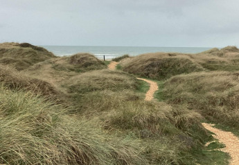 Sentier sinueux au milieu des dunes d’herbe menant à la mer près du « gîte 6 personnes à Pandrup », Danemark.