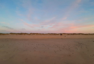Strandbillede ved solnedgang nær 6 personers feriehus i Pandrup, Danmark, med himmel i pastelnuancer.