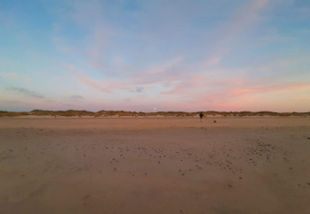 Spiaggia sabbiosa al tramonto vicino alla casa vacanze per 6 persone a Pandrup, Danimarca, cielo pastello.
