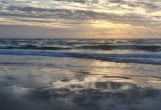 Zonsondergang aan het strand bij een 6-persoons vakantiehuis in Pandrup, Denemarken, rustige golven.