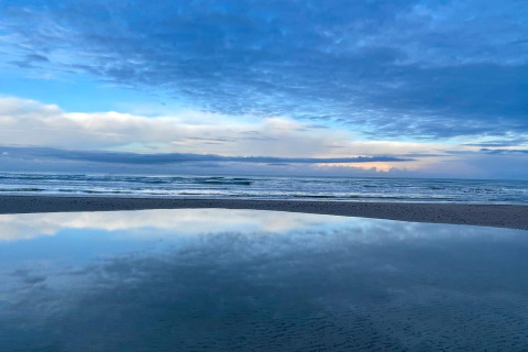 Prachtig uitzicht op zee en lucht met reflectie in het water op een strand in Pandrup, Denemarken.