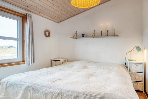 Chambre d'une maison de vacances pour 6 personnes à Pandrup, Danemark, avec lit double et lampes de chevet.