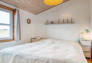 Chambre d'une maison de vacances pour 6 personnes à Pandrup, Danemark, avec lit double et lampes de chevet.