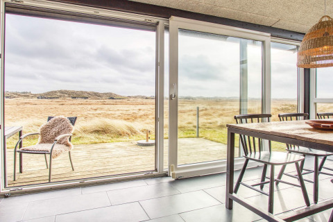 Zona pranzo luminosa con ampie vetrate e vista panoramica nella casa vacanze per 6 persone a Pandrup, Danimarca