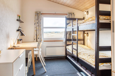 Lichte kamer met stapelbedden en bureau in het '6-persoons vakantiehuis in Pandrup', Denemarken.