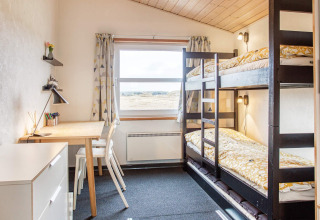 Lichte kamer met stapelbedden en bureau in het '6-persoons vakantiehuis in Pandrup', Denemarken.