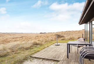 Uitzicht vanaf het terras van een 6-persoons vakantiehuis in Pandrup, Denemarken, met veld en blauwe lucht.
