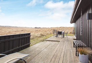 Udendørs terrasse ved feriehus til 6 personer i Pandrup, Danmark, med udsigt over åbne marker og klart vejr.