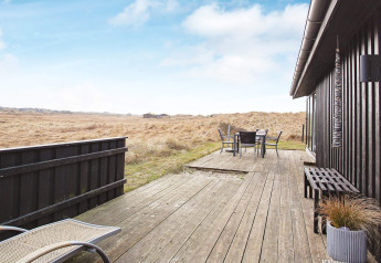 Houten terras bij 6-persoons vakantiewoning in Pandrup, Denemarken, met uitzicht op de omliggende natuur.