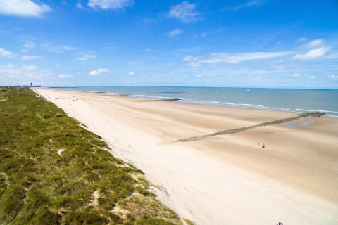 Strandzicht vanaf Breeduyn Village 3 in België, met brede zandstranden en groene duinen langs de kust.