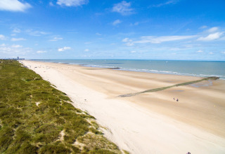Strandzicht vanaf Breeduyn Village 3 in België, met brede zandstranden en groene duinen langs de kust.
