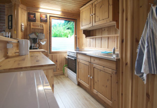 Acogedora cocina de madera con electrodomésticos modernos en Holiday home «Susanne 58 qm», Alemania.