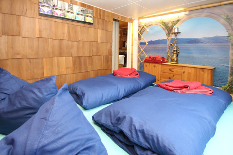 Bedroom at Holiday home Susanne in Germany, featuring blue bedding, wood walls, and lake view mural.