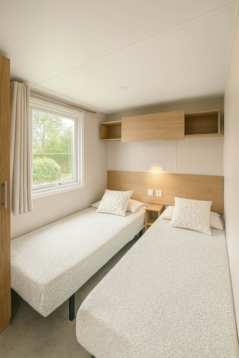 Lichte kamer met twee enkele bedden, ruim raam en houten wandkast in Holiday home (PL. 94), Camping Papillon, België.