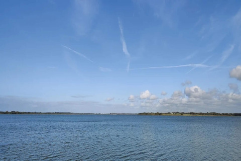 Vista lago e cielo azzurro da «casa vacanza per 4 persone a Frederiksværk» in Danimarca, sereno.