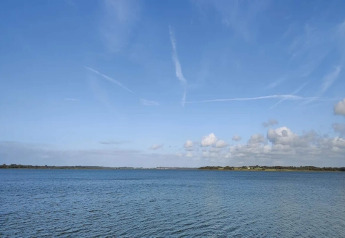 Vista de lago y cielo azul desde «Casa de vacaciones para 4 personas en Frederiksværk» en Dinamarca.