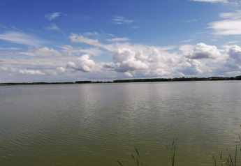 View of calm lake and cloudy sky at 4 person holiday home in Frederiksværk, Denmark.