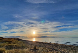Solnedgang over stranden ved Frederiksværk i Danmark, set fra en feriebolig for fire personer.