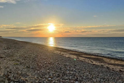 Vista del atardecer en la playa cerca de Frederiksværk, Dinamarca, tomada desde una casa vacacional costera.