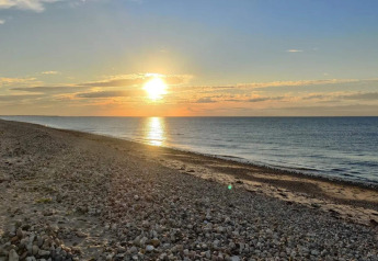 Coucher de soleil sur la plage près de Frederiksværk, Danemark, vu d'une maison de vacances au bord de la mer.