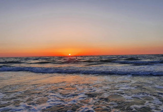 Zonsondergang aan zee bij ‘4-persoons vakantiehuis in Frederiksværk’, Denemarken, met golven en zachte kleuren.