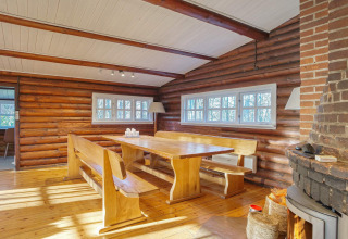 Lichte houten eetkamer in een blokhut met banken en ramen in Frederiksværk, Denemarken.