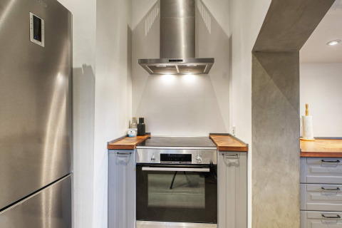 Moderne Küche in einer Ferienwohnung mit Edelstahlherd, Ofen und Dunstabzugshaube in Frederiksværk, Dänemark.