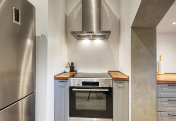 Modern kitchen at a holiday home featuring a stainless steel stove, oven, and hood in Frederiksværk, Denmark.