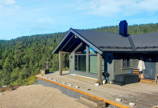 Modern chalet voor 6 personen in Passebekk, Zweden, met houten terras en panoramisch uitzicht op het bos.