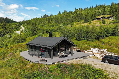 Chalet en bois avec terrasse dans un paysage verdoyant, forêt, voiture, été à Passebekk, Suède.