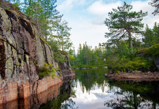 Vue pittoresque sur un lac entouré de rochers et de forêt près d’un chalet 6 personnes à Passebekk, Suède.