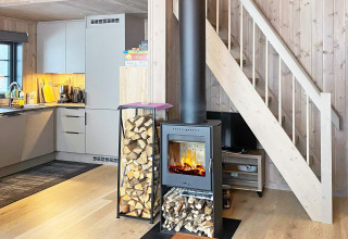 Intérieur d’un chalet avec poêle à bois, cuisine moderne et escalier à Passebekk, Suède.