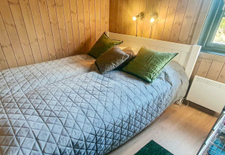 Chambre chaleureuse dans un chalet 6 personnes à Passebekk, Suède, avec mur en bois et lit double.