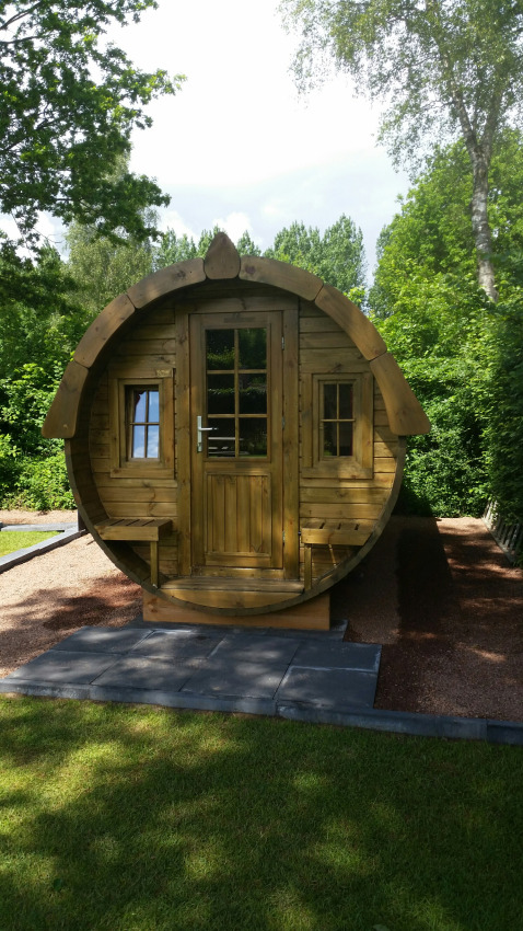 Cabaña redonda de madera para glamping con ventanas y bancos, en Parkcamping de Graafschap, Gelderland.