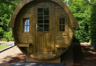 Cabane de glamping ronde en bois avec bancs et fenêtres au Parkcamping de Graafschap, en Gueldre.