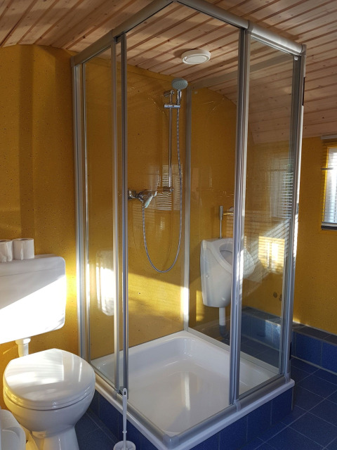 Baño en Camping Gieselwerder glamping con ducha, inodoro y urinario en un entorno acogedor.