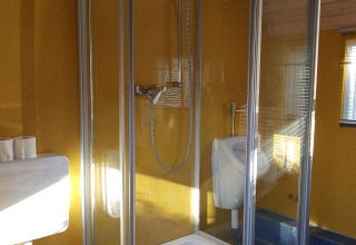 Badezimmer im Glamping bei Camping Gieselwerder mit Duschkabine, Toilette und Urinal in Hessen.