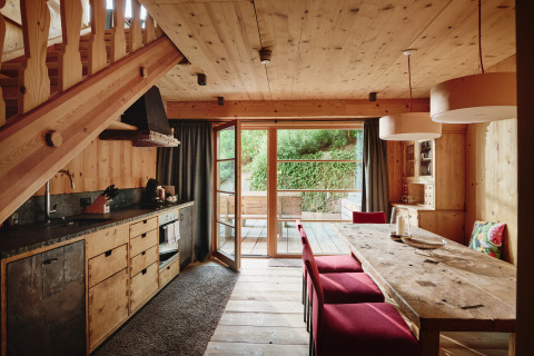 Gezellig houten interieur van HochLeger Chalet Refugium - Chalet Tirol met eettafel en terrasdeur.
