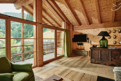 Interior view of HochLeger Chalet Refugium - Chalet Tirol, wooden finish, large windows and mountain views.
