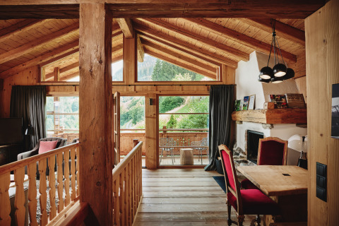 Indvendig billede af luksuriøs HochLeger Chalet Refugium - Chalet Tirol glamping med træinteriør og bjergudsigt.