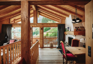 Binnenaanzicht van luxe HochLeger Chalet Refugium - Chalet Tirol glamping, met houten interieur en berguitzicht.