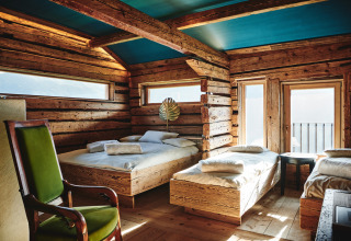 Hébergement glamping de luxe au HochLeger Chalet Refugium - Chalet Tirol, intérieur bois rustique et vue sur la montagne.